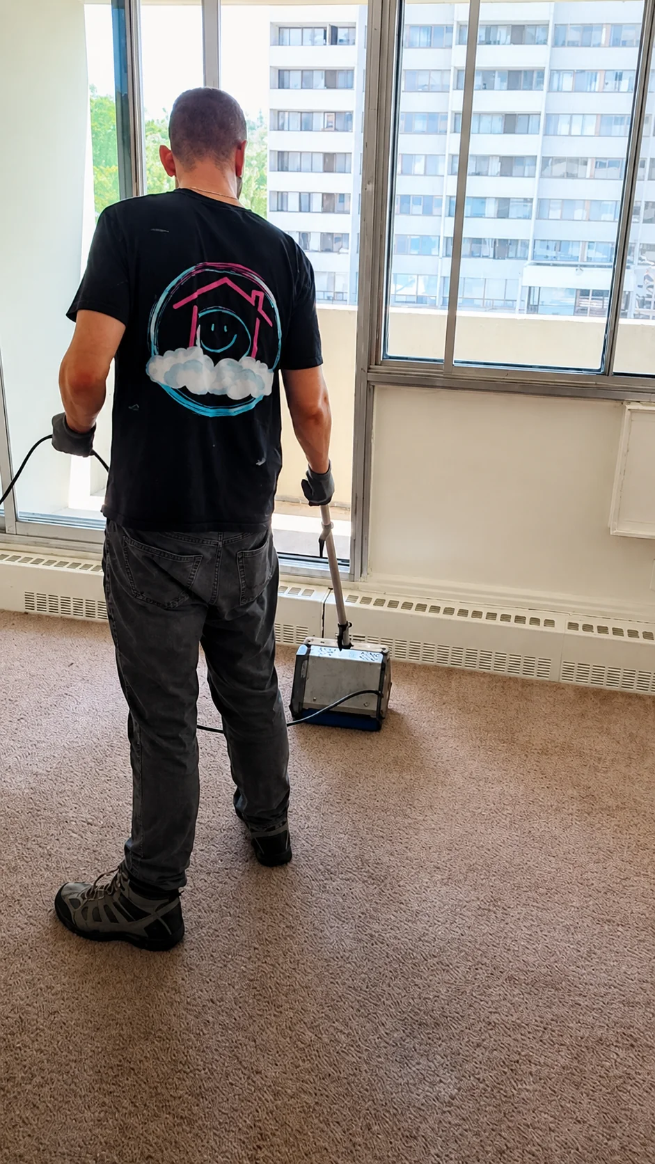 Happy House technician preparing carpet-cleaning equipment in an Ottawa apartment
